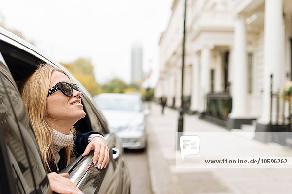 Junge Frau mit Sonnenbrille vom Autofenster aus  London  England  UK