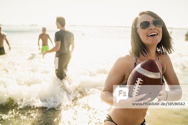 Junge Frau spielt American Football mit Freunden in Newport Beach  Kalifornien  USA