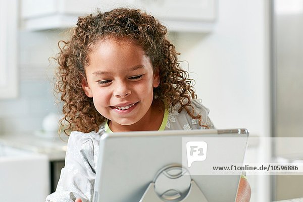 Girl using digital tablet looking down smiling