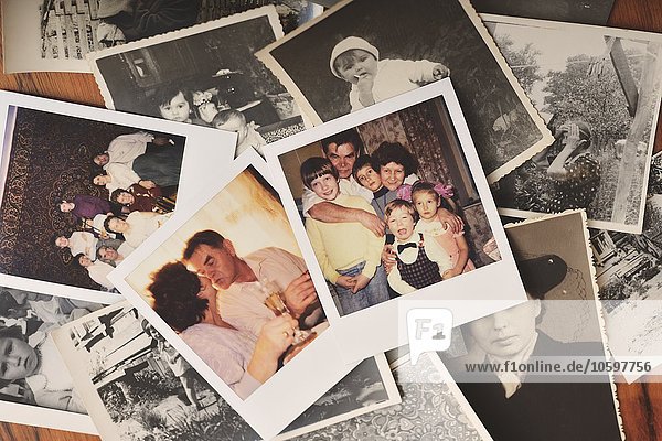 Pile of family photographs on table  overhead view