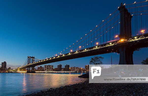 Manhattanbrücke vom Flussufer bei Nacht  New York  USA