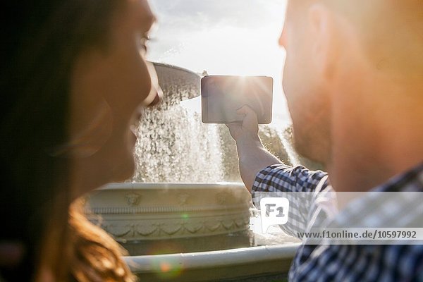 Paar nimmt Selfie am Telefon  Brunnen im Hintergrund