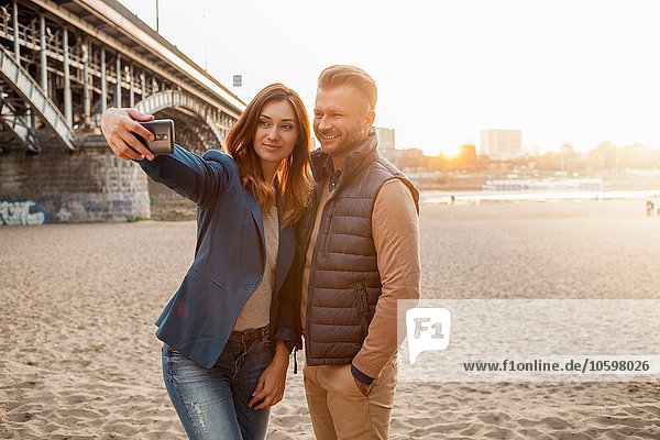 Mittleres erwachsenes Paar durch Brücke  die selfie am Telefon nimmt