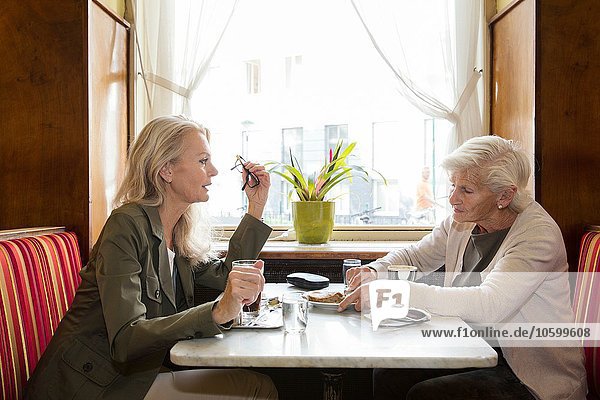 Mutter und Tochter sitzen zusammen im Café.