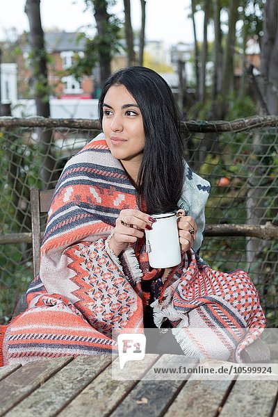 Junge Frau in Decke gehüllt mit Kaffee  Hampstead Heath  London