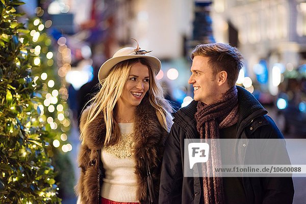 Romantic young couple strolling along New Bond street at xmas  London  UK