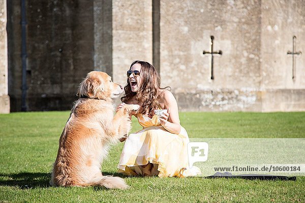 Frau posiert mit Tasse Tee und Golden Retriever Hund im Thornbury Castle  South Gloucestershire  UK