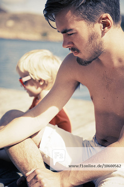 Junge entspannt sich mit seinem Bruder auf dem Bootssteg