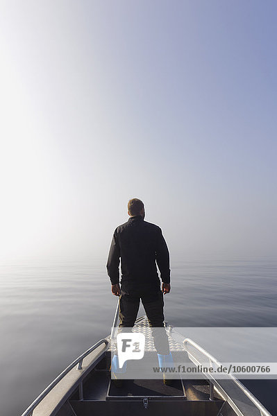 Mann auf Boot schaut aufs Meer