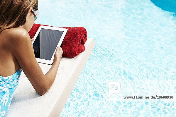 Mädchen mit Tablet-PC auf Pool-Floß