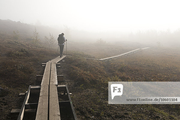 Teenage boy walking on wooden trail