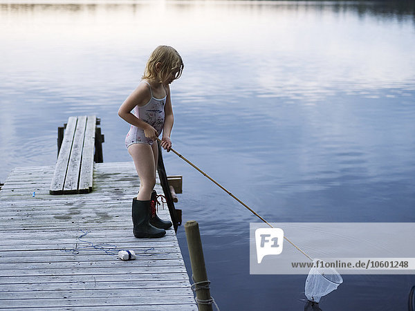 Girl standing on jetty with fishing net