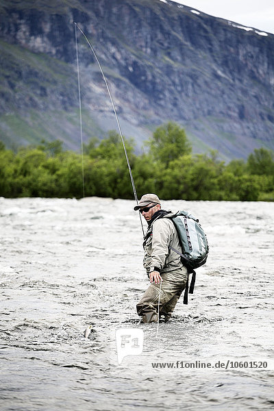 Mann beim Fischen im Gebirgsfluss