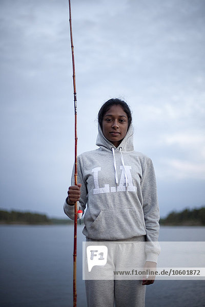 Young woman with fishing rod at evening