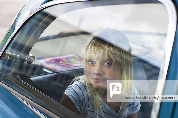 Girl sitting on back seat and looking at camera