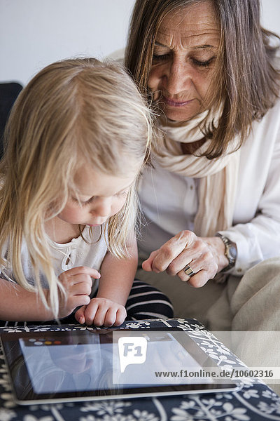 Grandmother with granddaughter using laptop