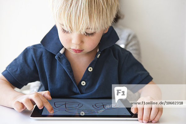 Junge zeichnet auf digitalem Tablet