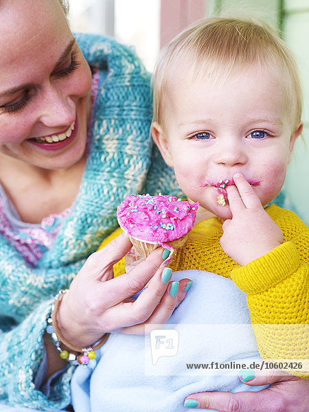 Mutter füttert Kleinkind mit Törtchen  Djurgarden  Schweden