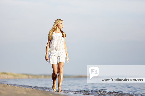 Frau geht am Strand spazieren