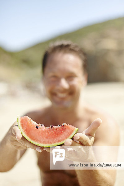Mann hält Wassermelone