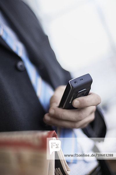 Businessman holding cell phone  close-up
