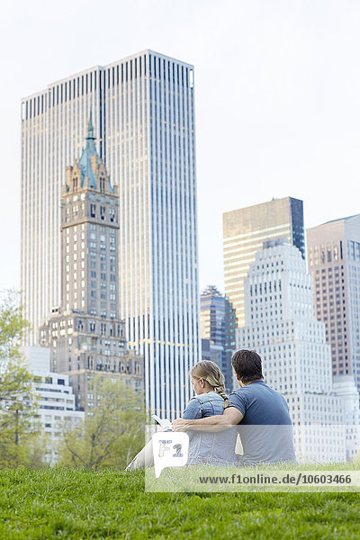 Paar sitzt zusammen  Wolkenkratzer im Hintergrund