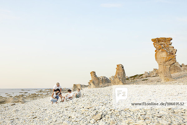 Familie am Strand  Felsformationen im Hintergrund