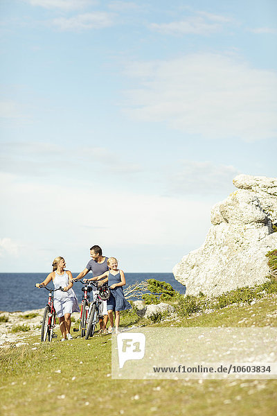 Family with bicycle at sea