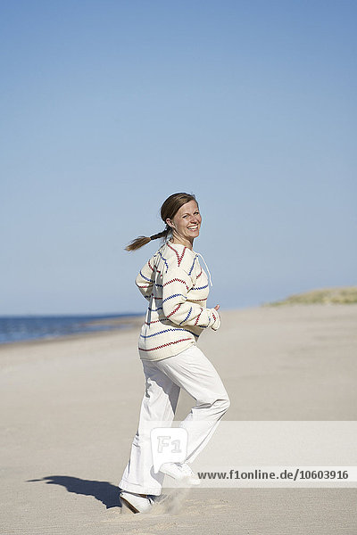 Happy woman jogging on beach