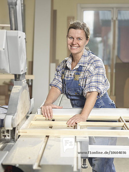Frau in Werkstatt mit Holzbohle