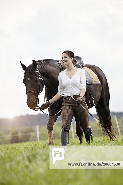 Frau zu Fuß mit Pferd