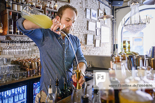 Barman preparing drink behind bar