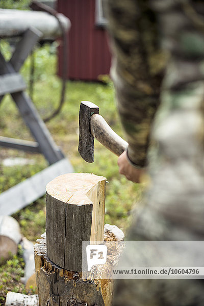 Frau beim Holzhacken