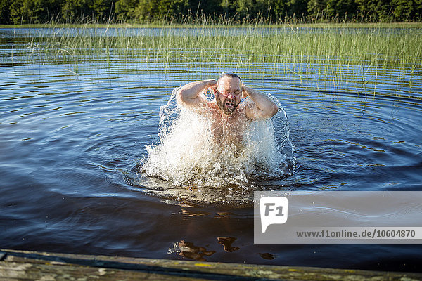 Mann schwimmt im See