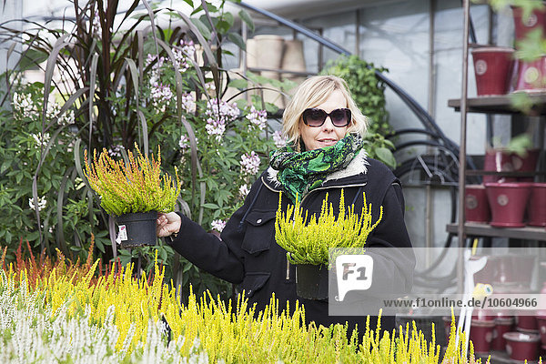 Frau wählt Pflanzen im Gartencenter aus