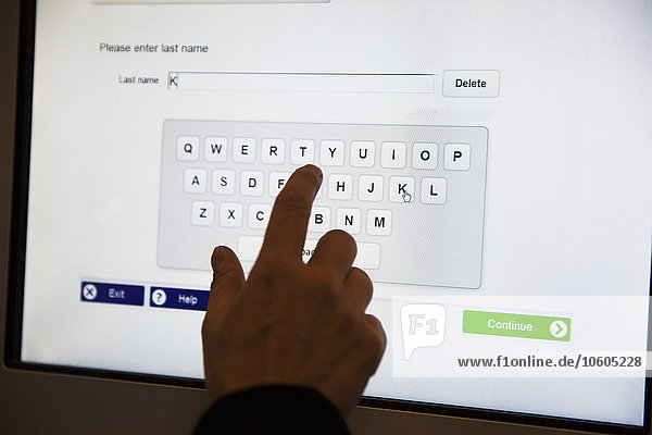 Hand drückt Tastatur auf Touchscreen