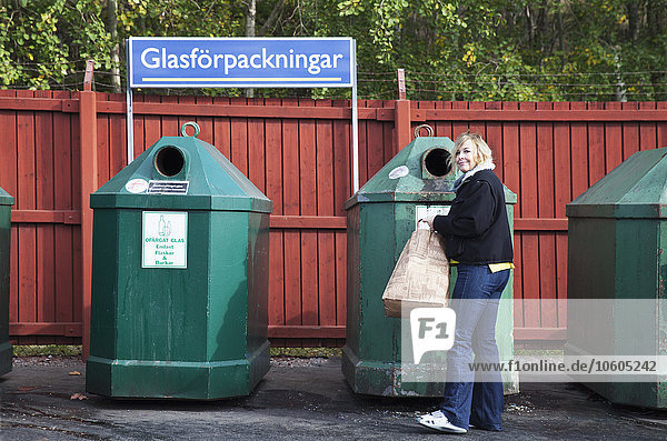 Frau in der Nähe der Recycling-Tonne