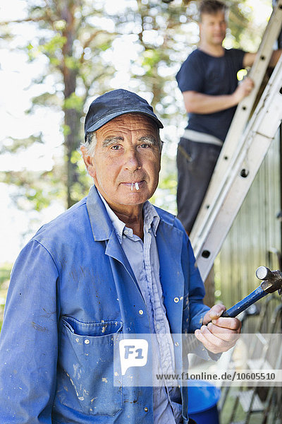 Portrait of senior man with hammer
