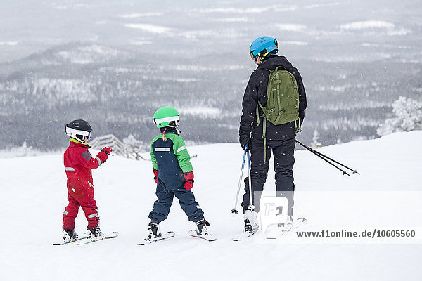 Vater mit Kindern beim Skifahren