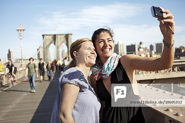 Zwei Touristinnen machen ein Selfie auf der Brooklyn Bridge