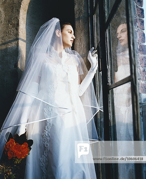 Nahaufnahme der Braut  die aus dem Fenster schaut.