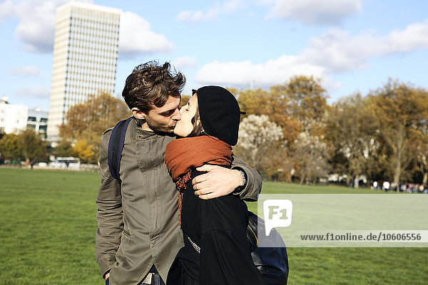 A young couple kissing in Hyde Park  London.