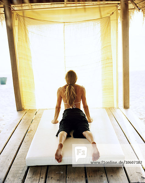 A Scandinavian woman performing yoga  Thailand.