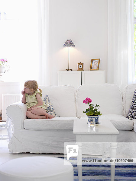Ein Mädchen sitzt auf einer Couch  Skane  Schweden.