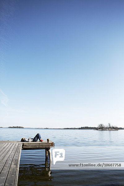 Frau auf einem Steg liegend  Schweden.