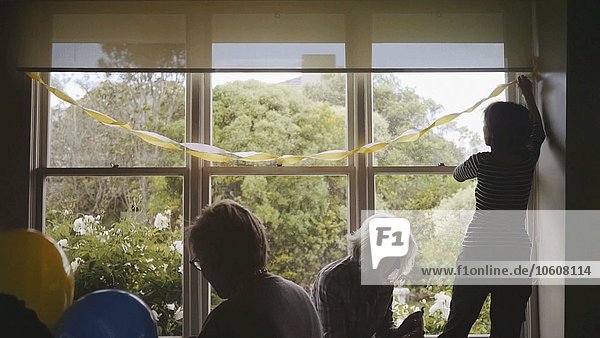 Dekoratives Partyband flattert  während drei Frauen den Raum für die Party dekorieren