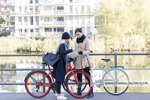 Frauen mit Fahrrädern schauen auf die Karte