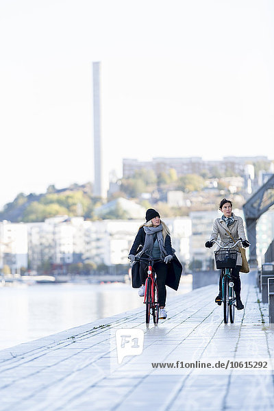 Frauen auf Fahrrädern auf der Promenade