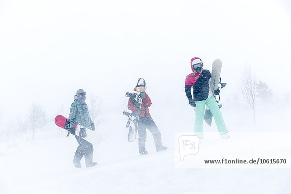 Männer mit Snowboard an einem verschneiten Tag