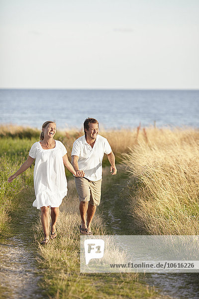 Glückliches Paar beim Spaziergang am Meer